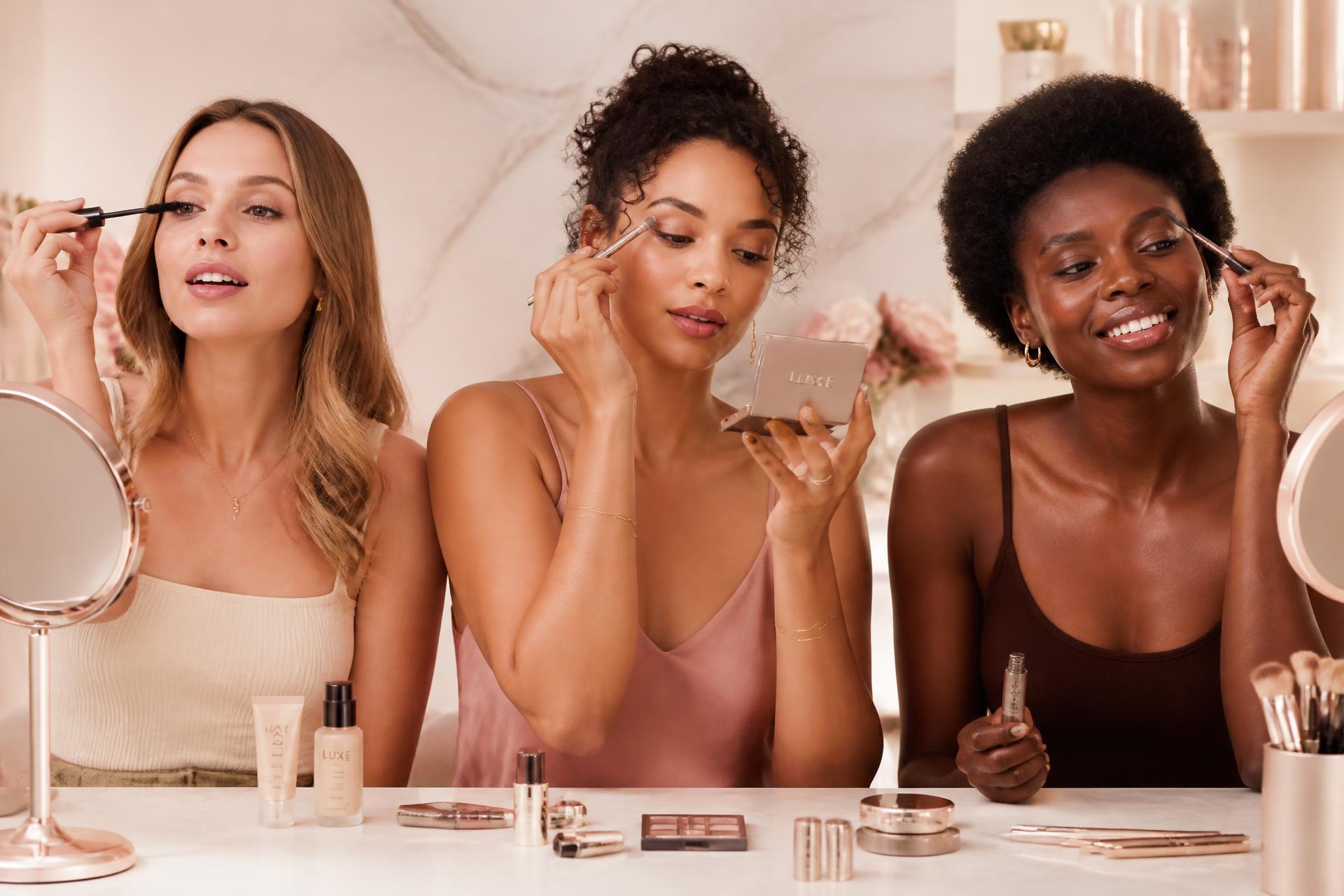 Trois femmes aux teints différents se maquillant ensemble : mascara, ombre à paupières et sourcils